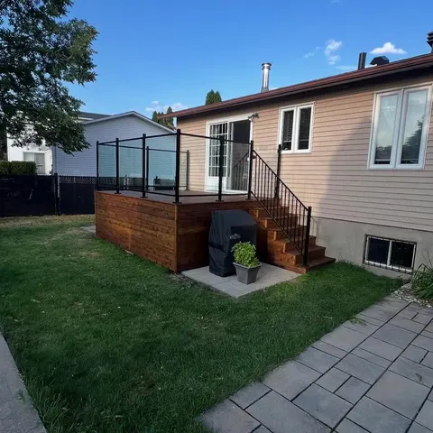 Wood deck with black aluminum railing and paver patio