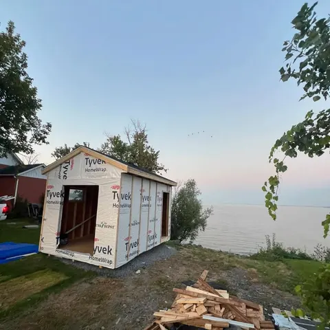 Lakeside shed under construction, framing wrapped in air barrier